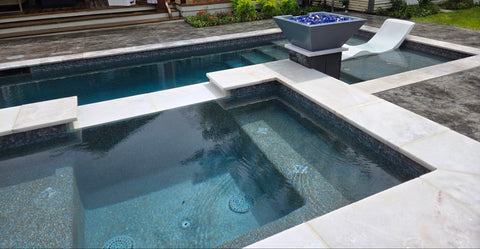 In-ground pool with spa area in a residential backyard

