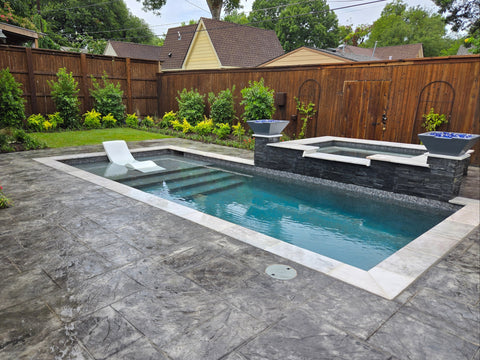 Small rectangular pool with hot tub in a backyard setting

